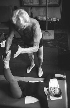 Instructor de Pilates trabajando individualmente con un cliente, mostrando la atención personalizada