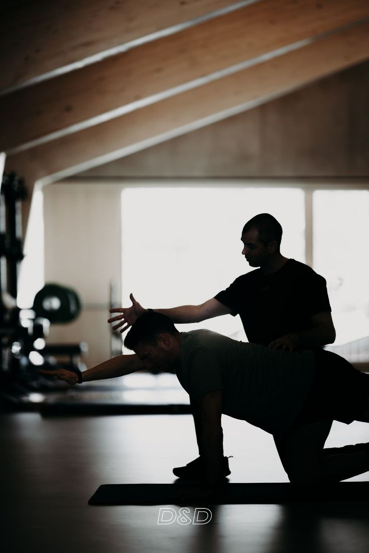 Instructor de Pilates corrigiendo postura en reformer, ambiente profesional de estudio